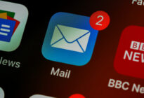 Ein Smartphone-Bildschirm zeigt das Symbol einer E-Mail-App mit einer roten Benachrichtigung, die zwei ungelesene E-Mails anzeigt.