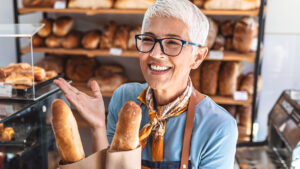 Frau beim Bäcker kauft Baguette